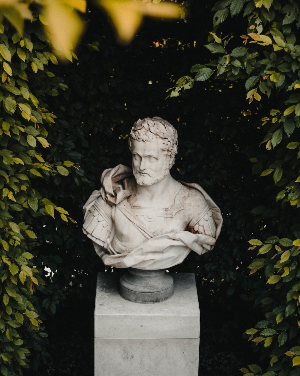 Photo by Mike Gorrell a statue of a man sitting on top of a cement block